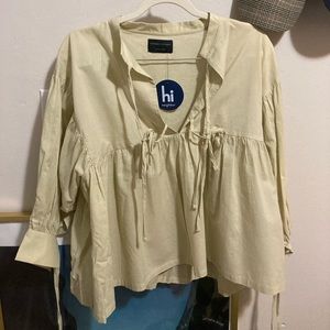 Beige peasant top with neck and sleeve ties.